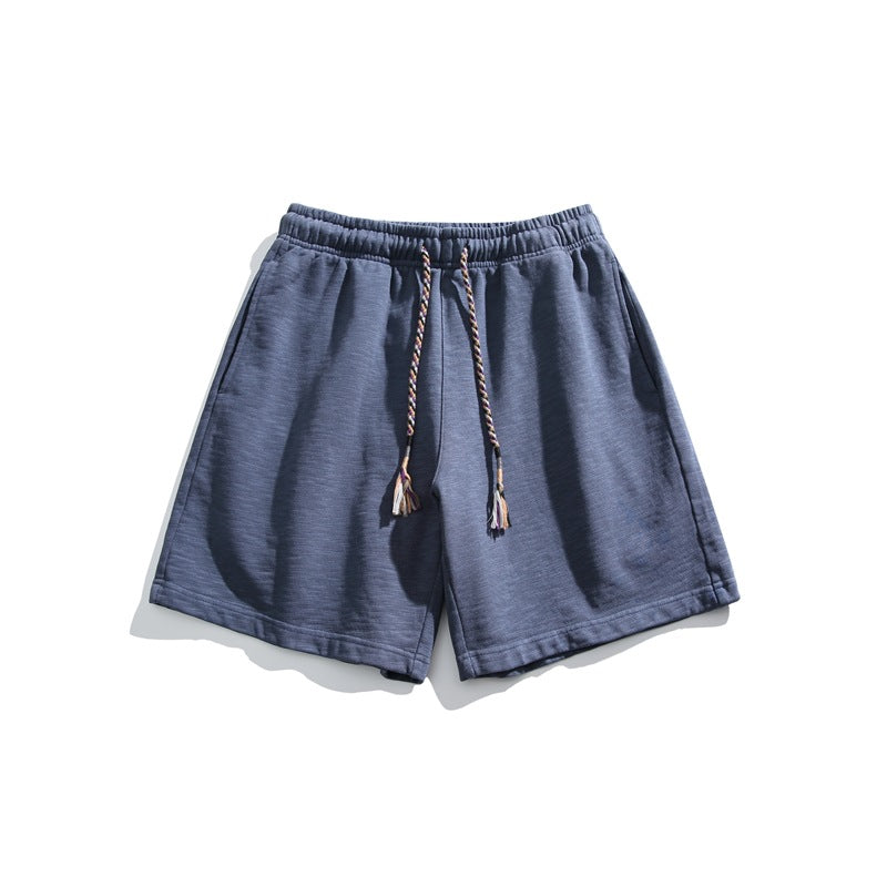 Navy blue textured knit shorts flat lay with elastic waistband and braided tassel drawstring