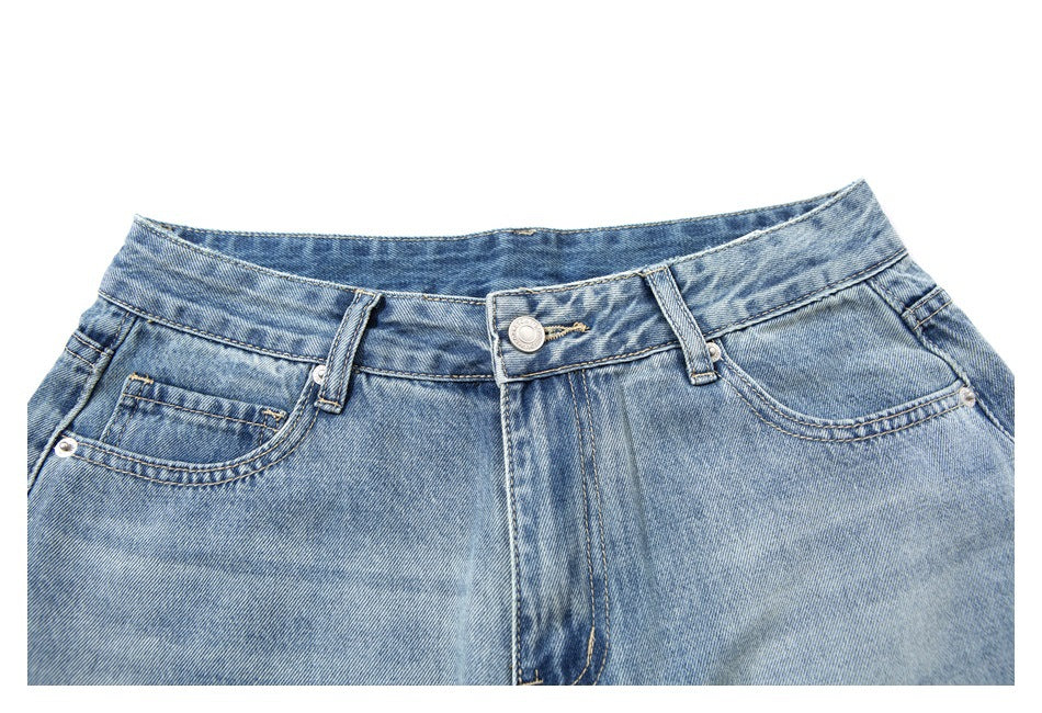 Close-up front view of light blue washed jeans with button closure, belt loops, and front pockets.