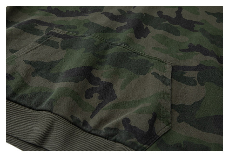 Close-up of a camouflage hoodie kangaroo pocket and ribbed hem.
