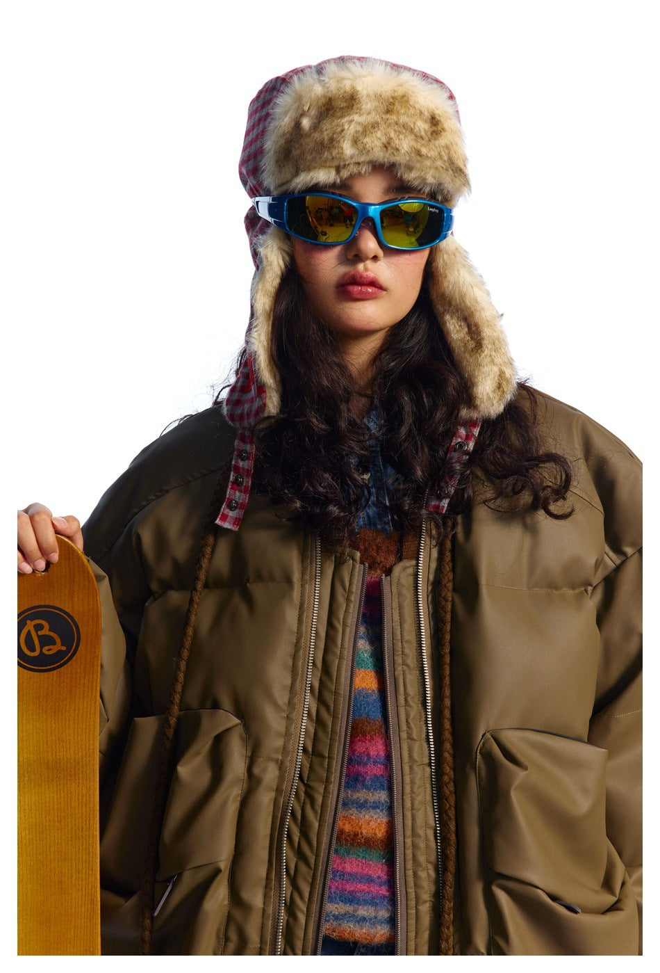Model in an oversized olive-brown padded bomber jacket with large pockets and brown ribbed trim, shown from the front.