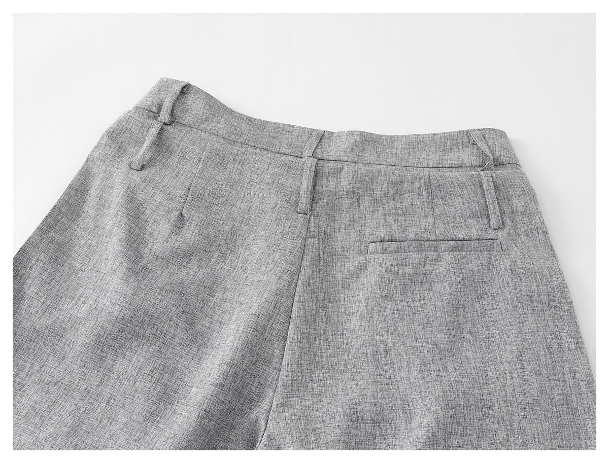 Upper back view of light gray trousers with belt loops and a single welt pocket.