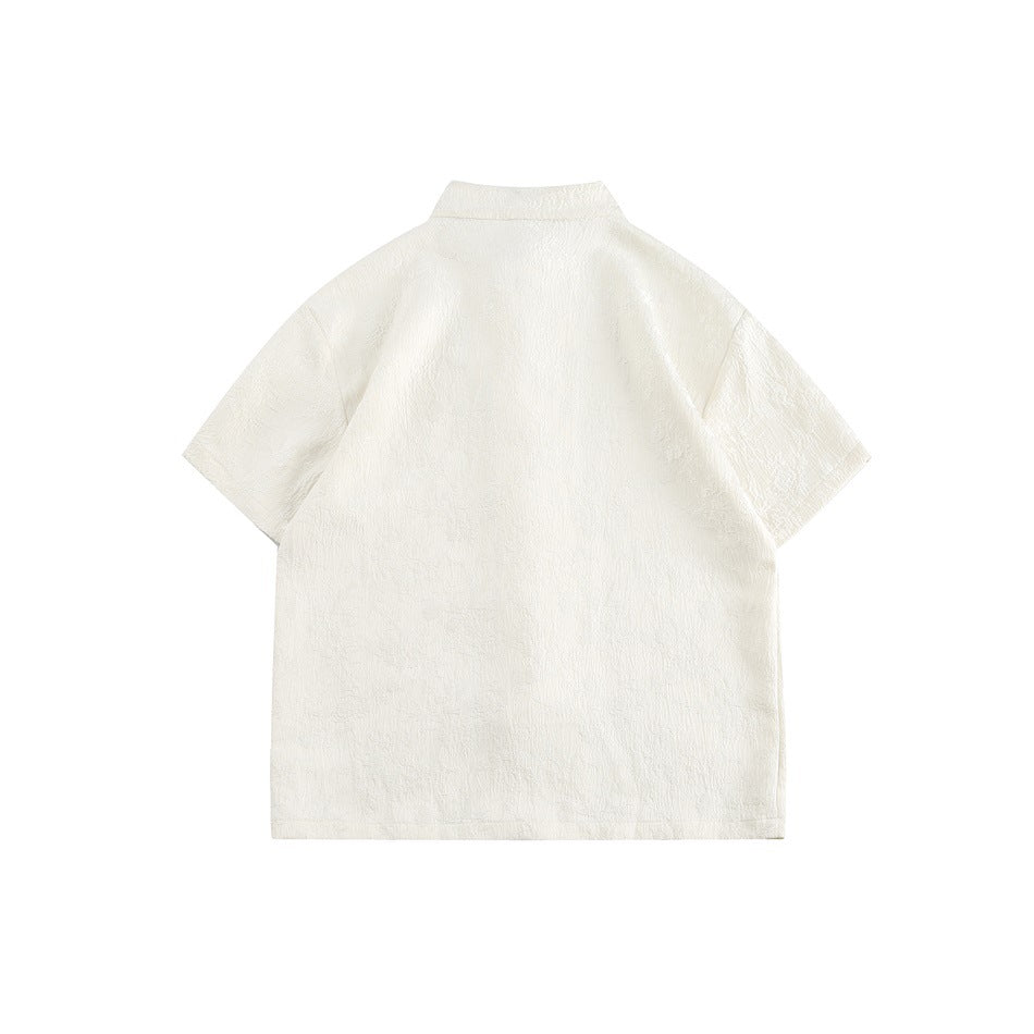 Back view of an ivory short-sleeve top with a standing collar and subtle textured pattern.