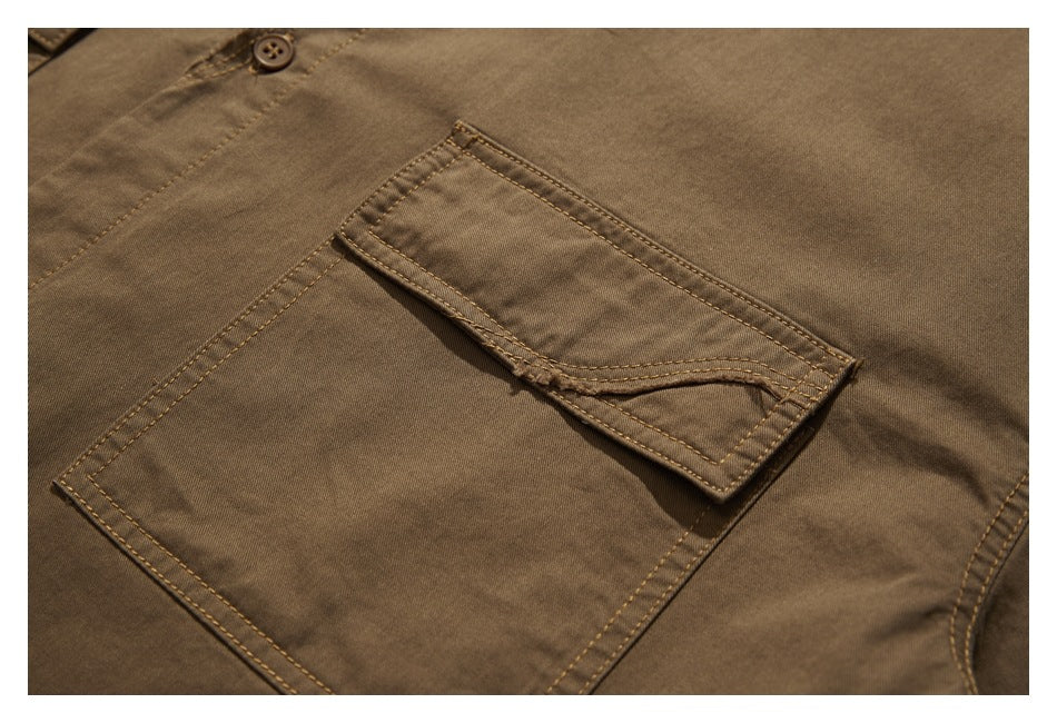 Close-up of a brown shirt pocket with a buttoned flap and contrasting topstitching.