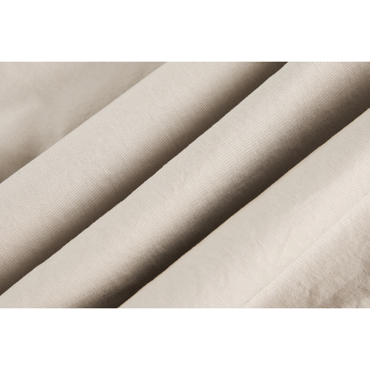 Macro view of beige fabric with fine diagonal ribbed texture.