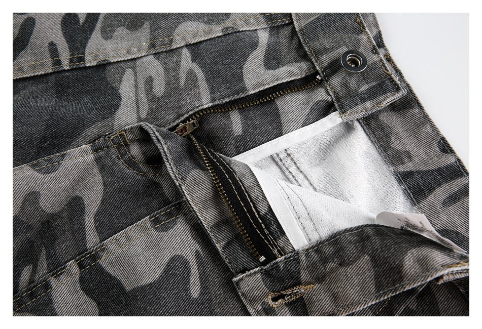 Close-up of the open zipper fly, button and inner waistband of gray camouflage denim pants.