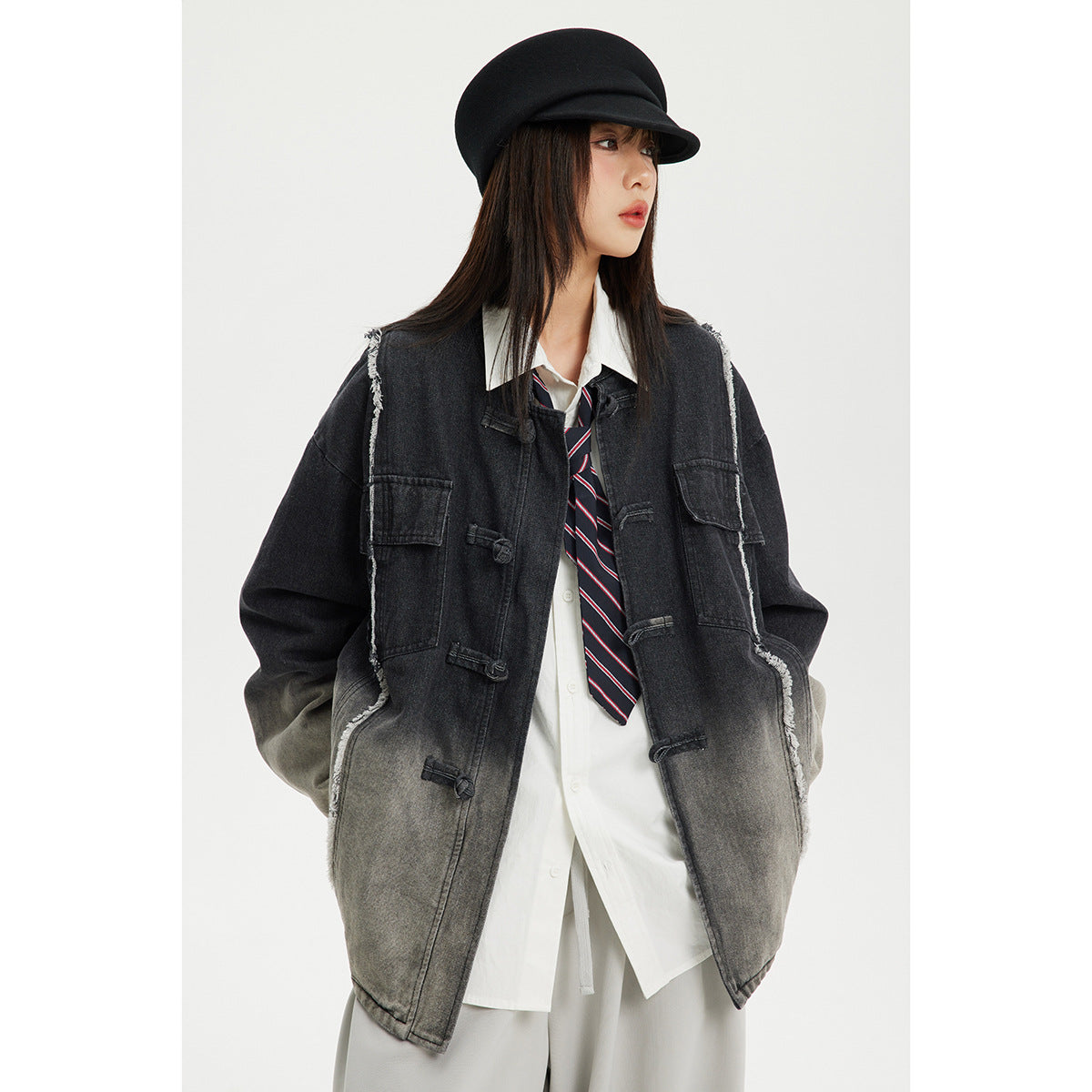 Front view of a model wearing a long charcoal and gray ombré jacket with frayed seams, toggle closures, and patch pockets.