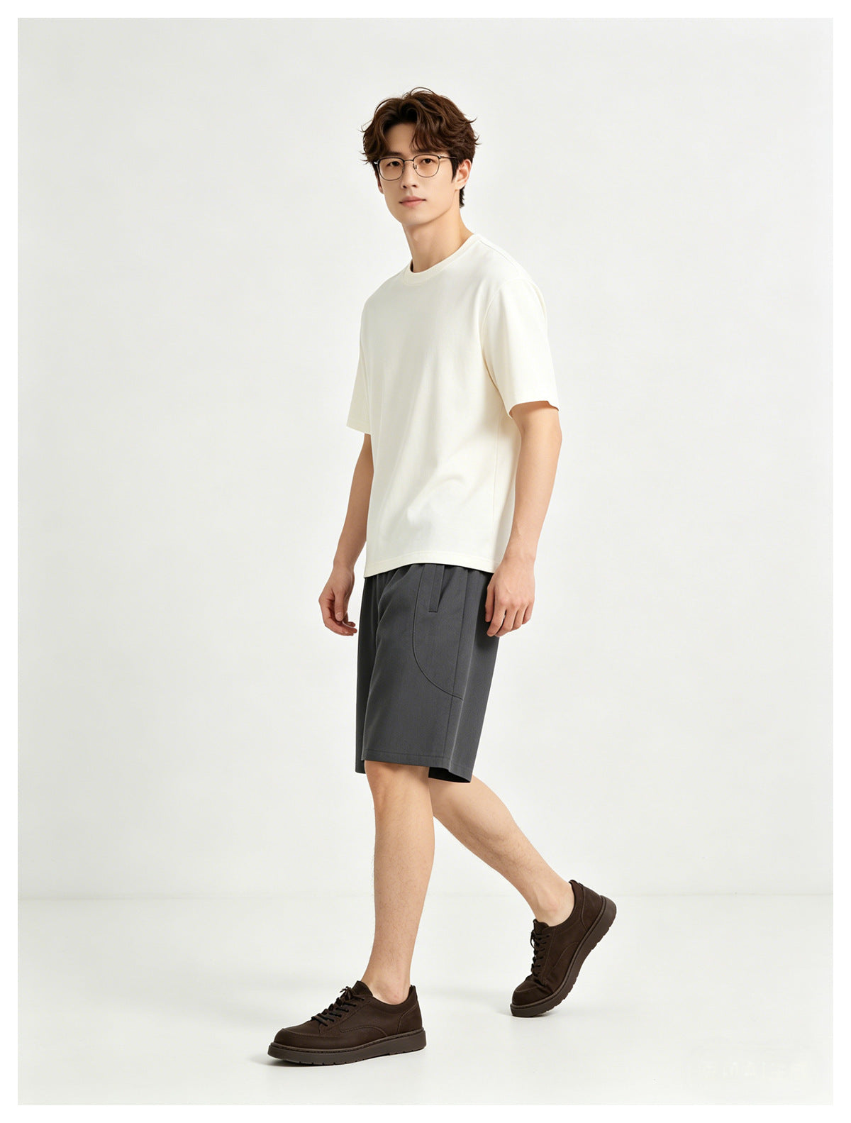 Model wearing a plain white crew-neck T-shirt and charcoal shorts, shown from a three-quarter front angle.