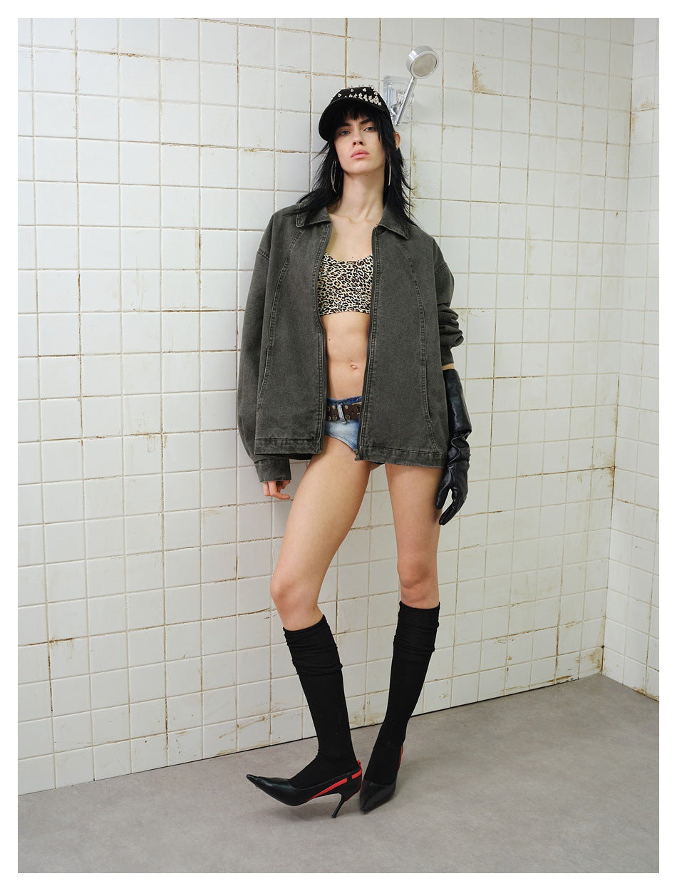Model wearing an oversized green washed zip jacket open over a leopard top, with black knee socks and heels