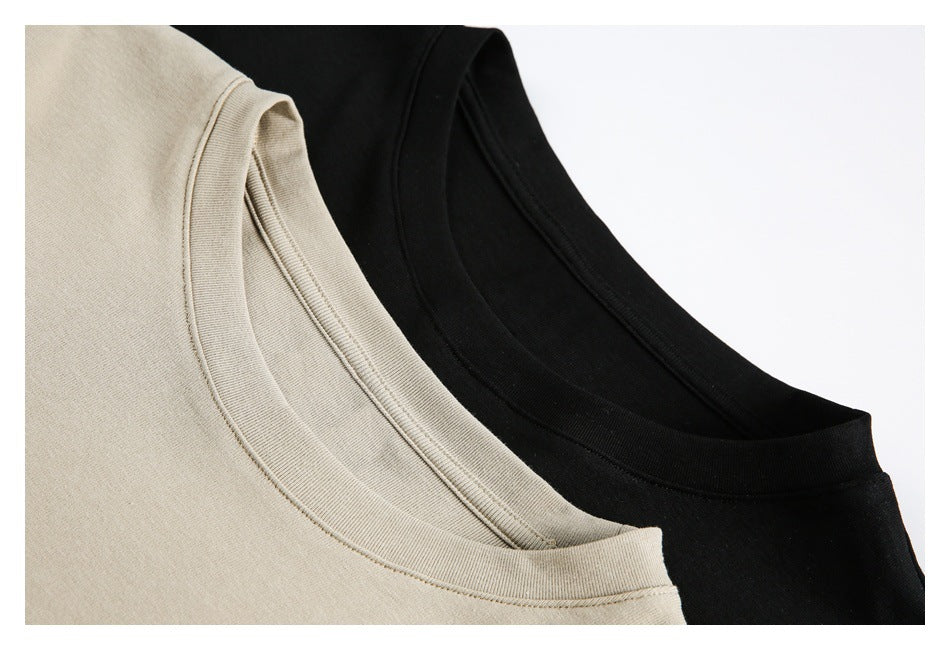 Close-up of beige and black crew necklines, showing ribbed collars and stitching.