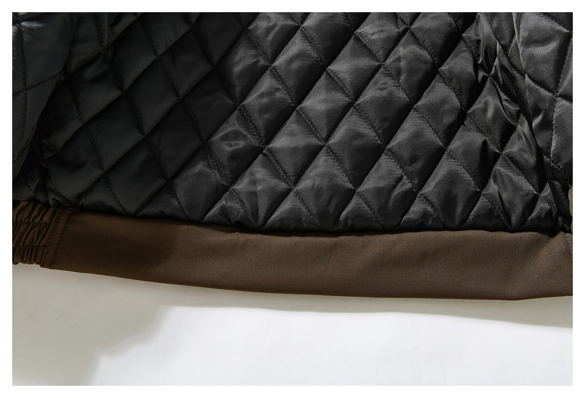 Close-up of the jacket’s black diamond-quilted lining above the brown hem.