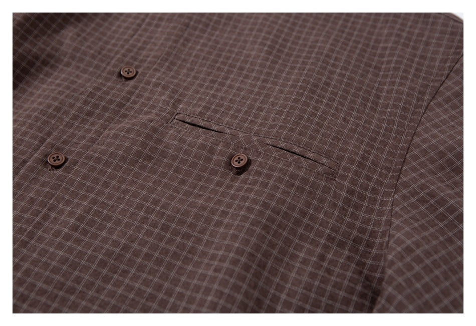 Close-up of a brown small-check shirt showing buttons and a chest pocket.