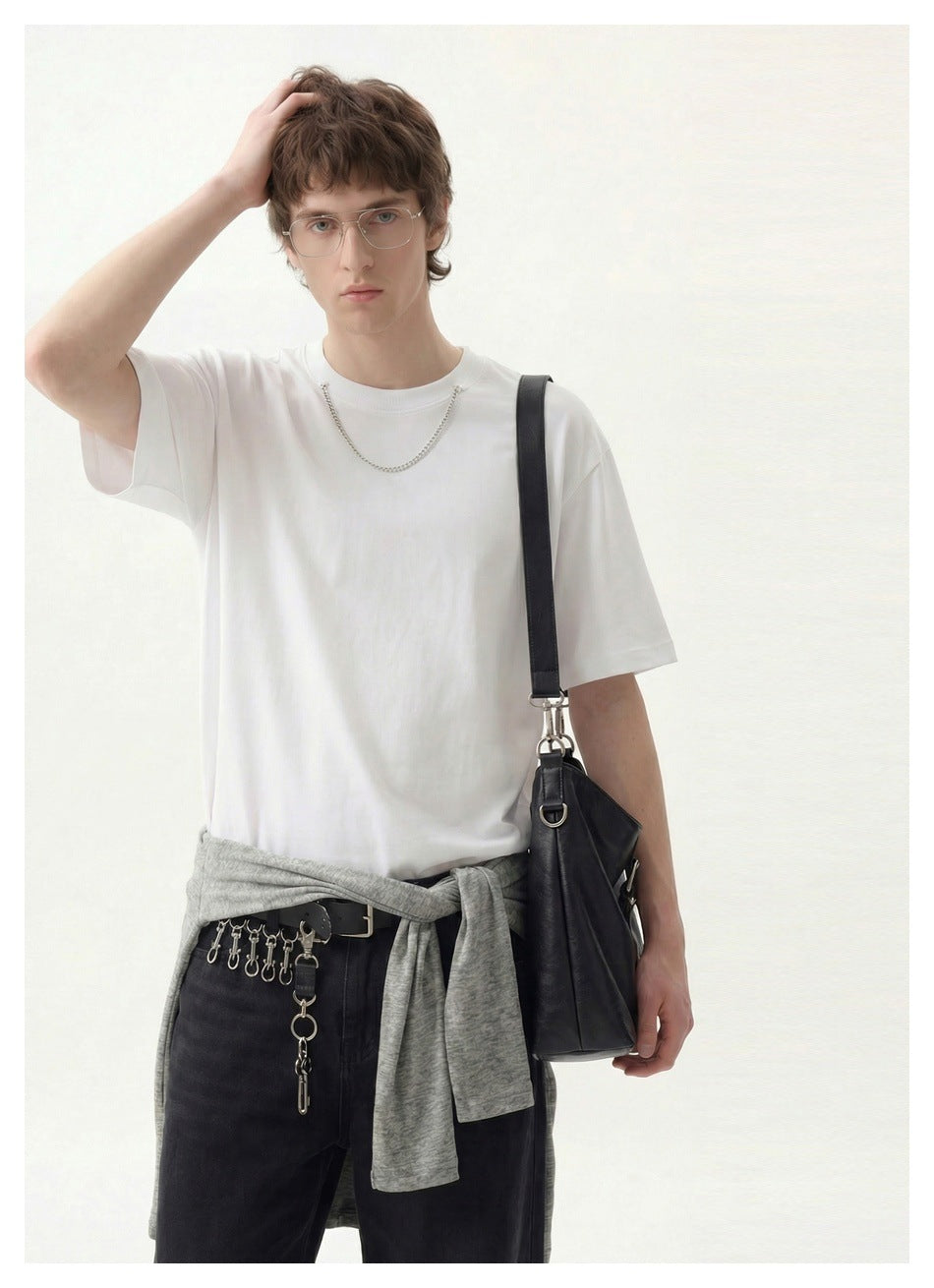 Model wearing a plain white short-sleeve crew-neck T-shirt, shown from the front with a shoulder bag.
