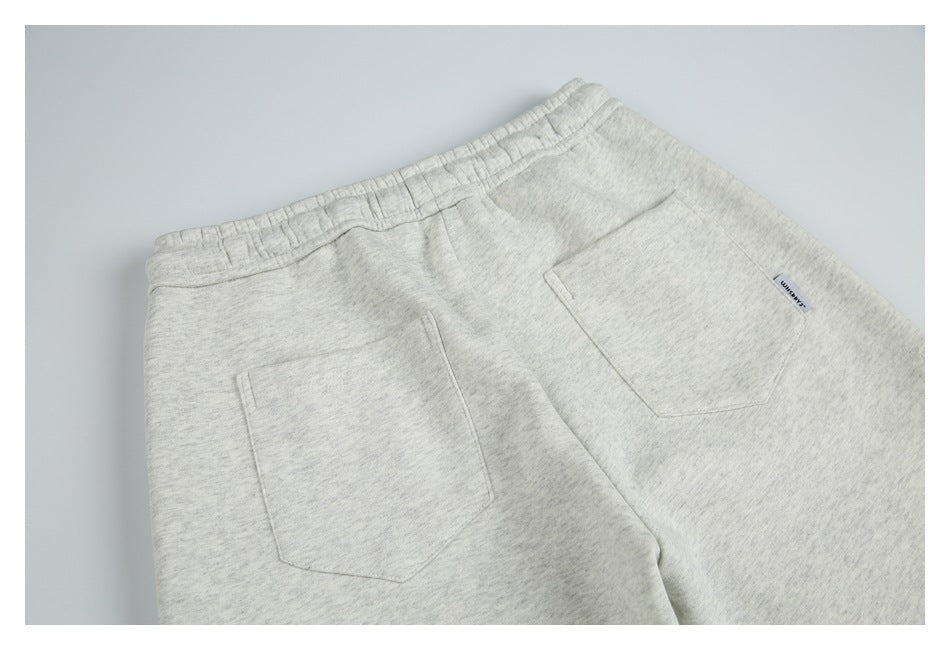 Partial rear view of light heather gray shorts laid flat, with an elastic waist and two patch pockets.