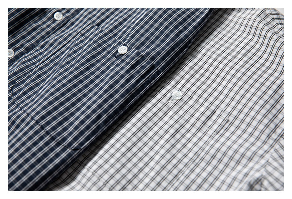 Overlapping navy and white plaid shirts shown close up, with white buttons visible.