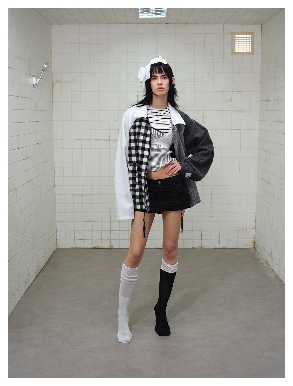 Full-length model wearing a white, checked, pinstriped, and charcoal color-block jacket with a striped top and black skirt.