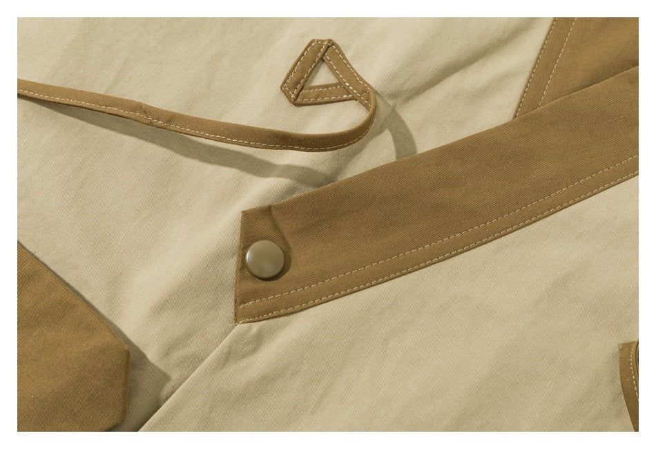 Close-up of a beige garment's brown trim, fabric loop, and round snap fastener.