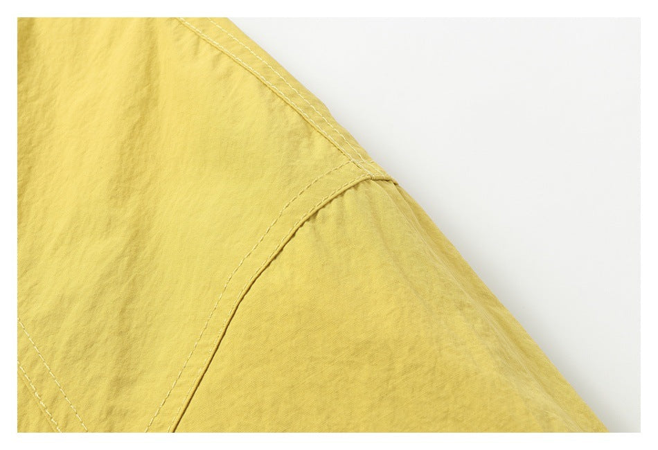 Close-up of the mustard-yellow jacket's shoulder seam and sleeve construction.