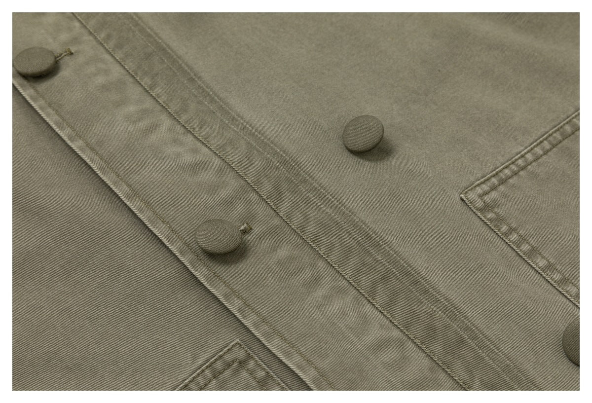 Close-up of the olive-gray jacket's button-front placket with covered buttons and a partial pocket.