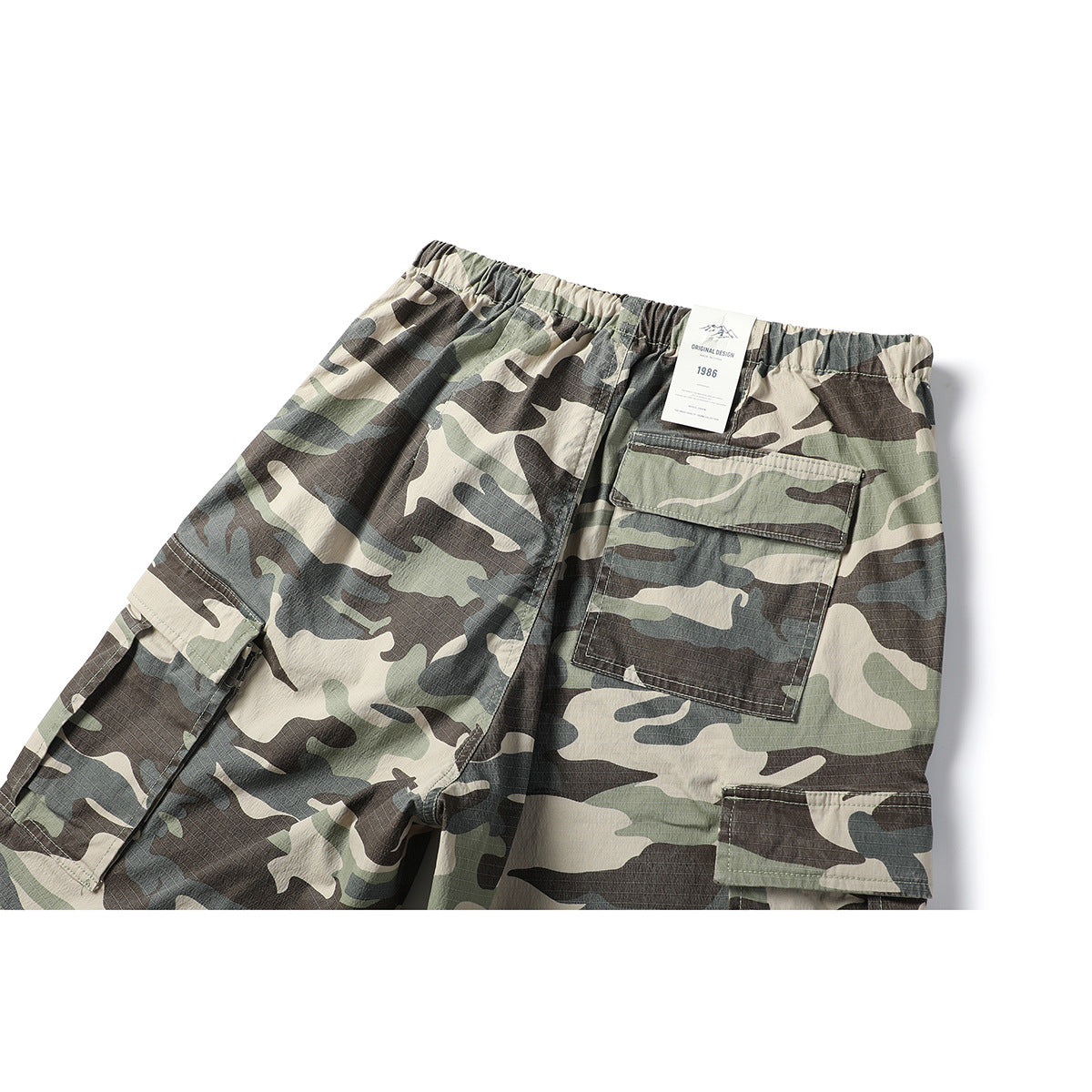 Upper back view of loose camouflage cargo pants with an elastic waist and large rear pocket.