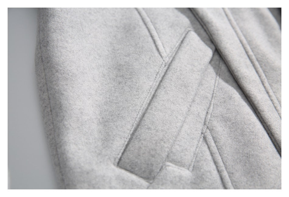 Close-up of a welt pocket and seams on a light gray coat.