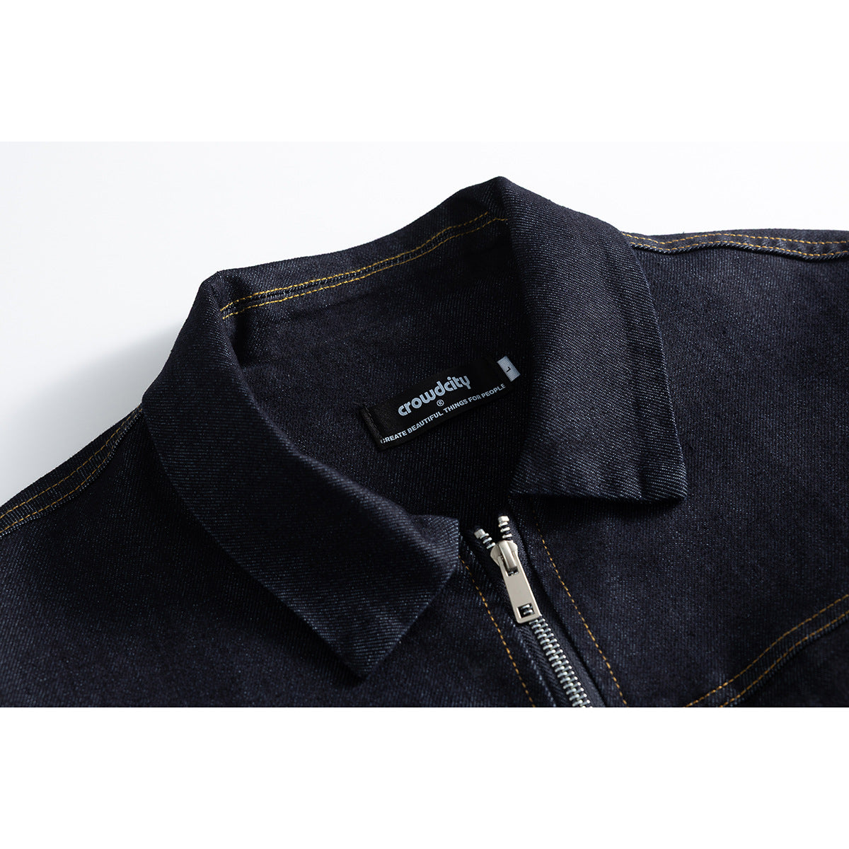 Close-up of a dark indigo jacket collar and silver zipper, with a black English-text label inside.