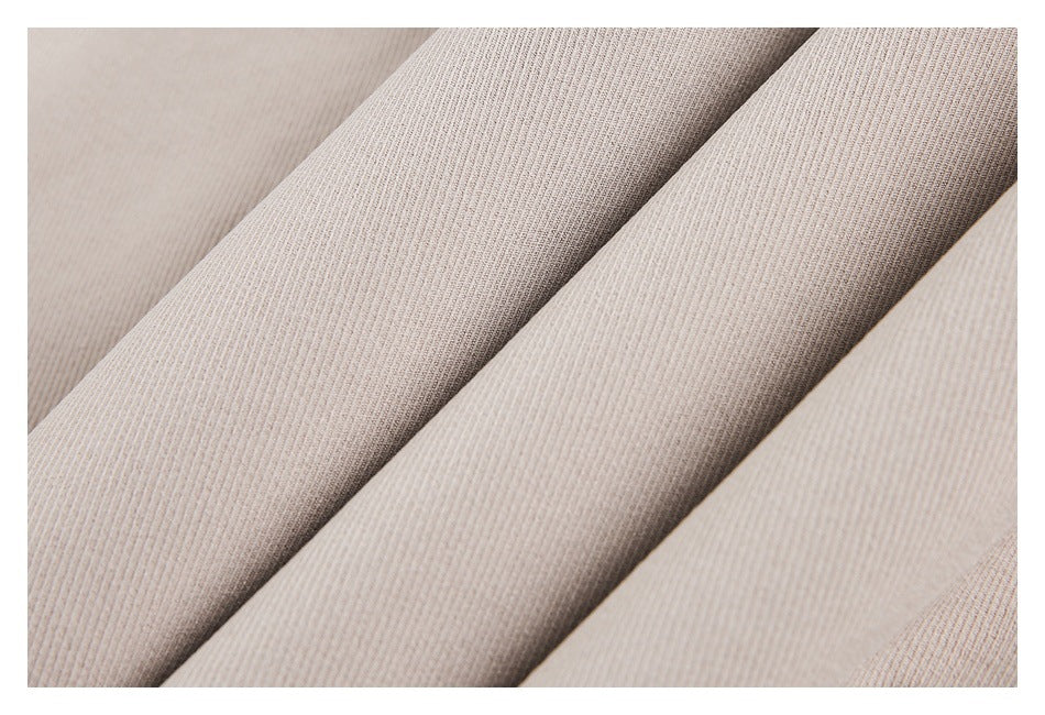 Close-up of beige garment fabric arranged in overlapping folds.