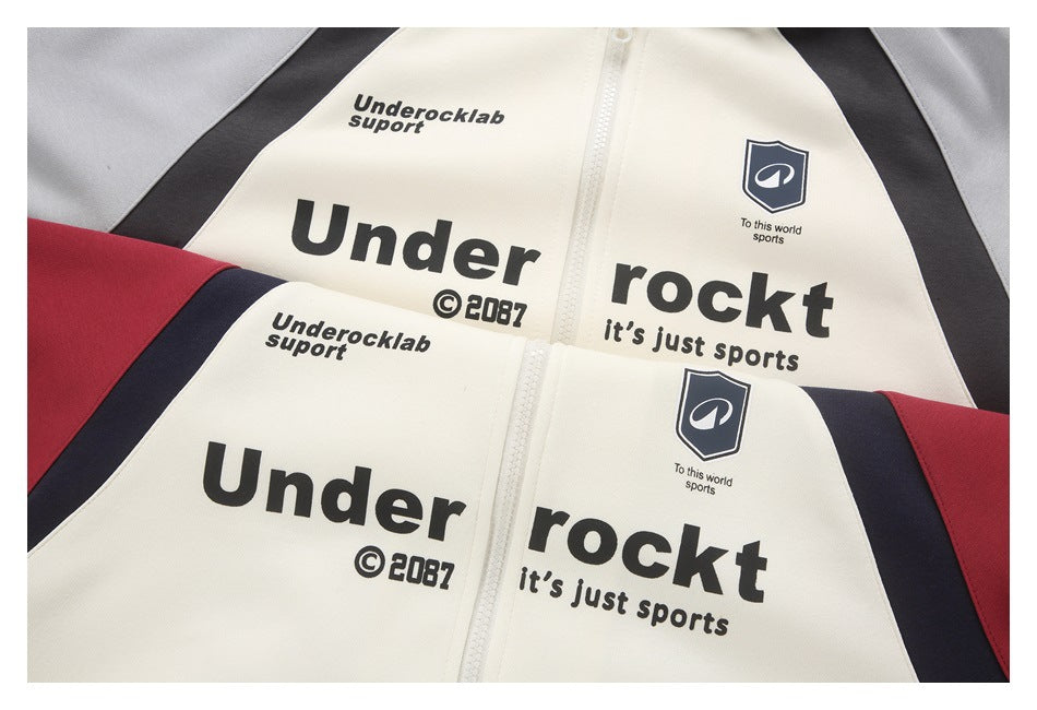 Close-up of cream zip-front jackets with red, navy, and gray panels and printed black graphics.