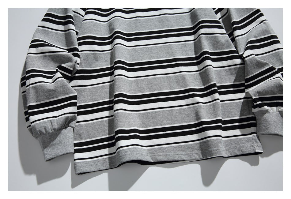 Cropped front view of a gray long-sleeve shirt with black and white horizontal stripes.