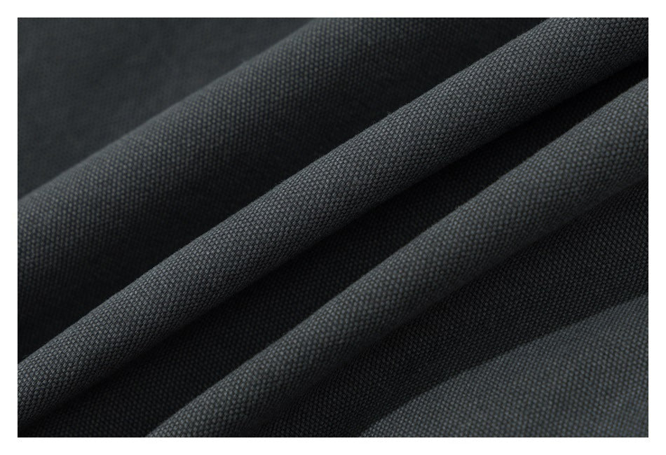 Macro view of dark charcoal fabric folded to show its woven surface texture.