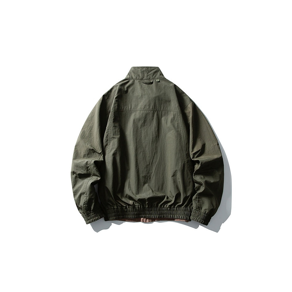 Back view of a dark olive jacket with a stand collar, long sleeves, and elasticated cuffs and hem.