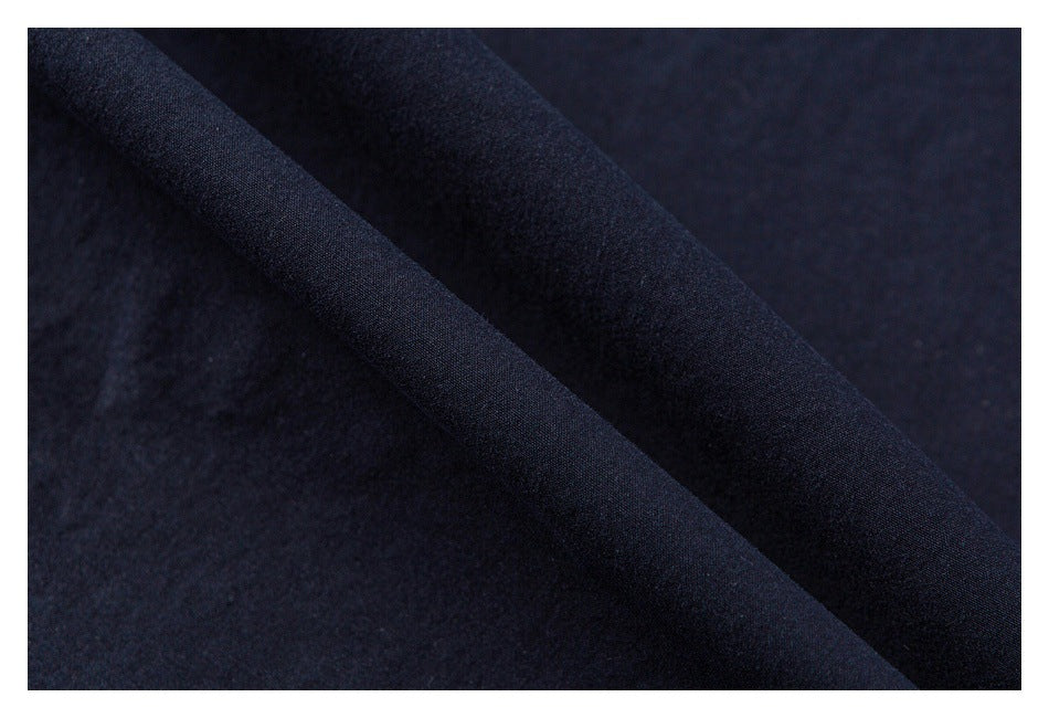 Close-up of folded navy fabric showing its surface and drape.