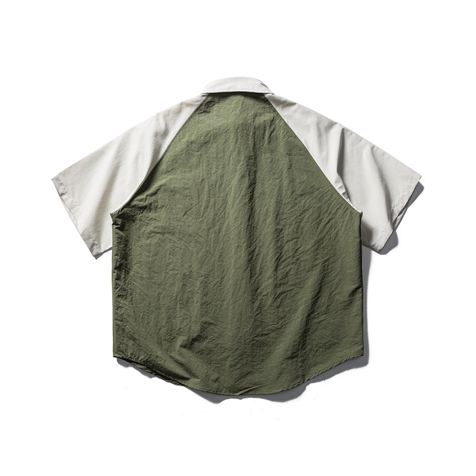 Back view of short-sleeve raglan shirt with army green back panel and light gray-beige sleeves and collar, flat lay