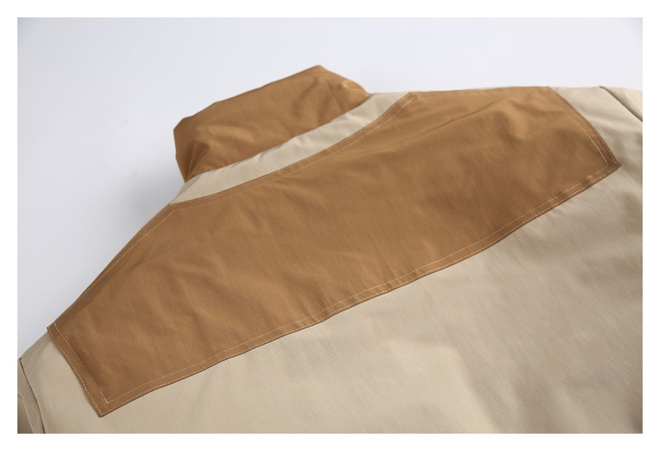 Close-up of a tan garment with a large brown stitched panel and beige fabric.