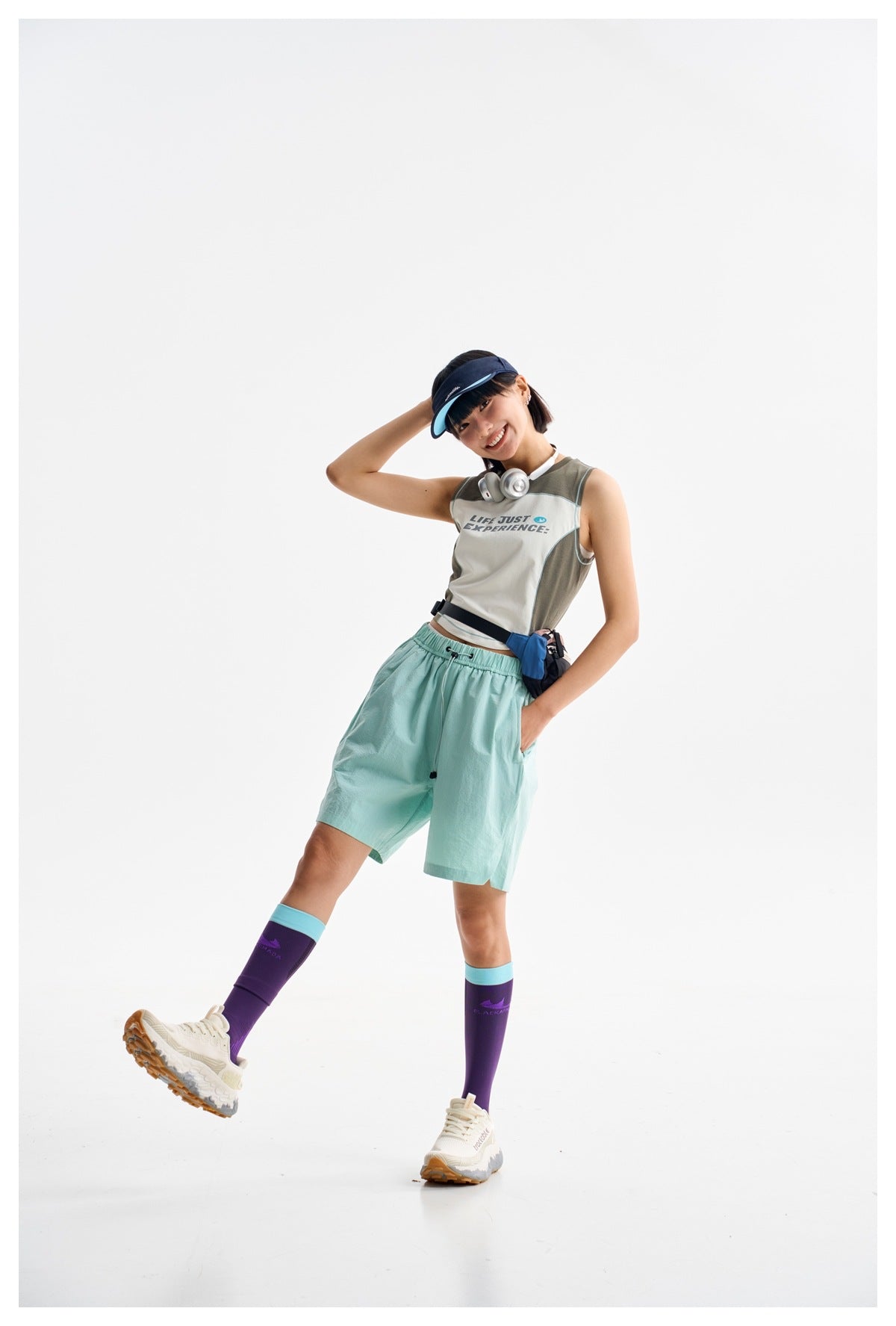 Model wearing a color-block sleeveless crop top and loose mint-green shorts with an elastic drawstring waist.