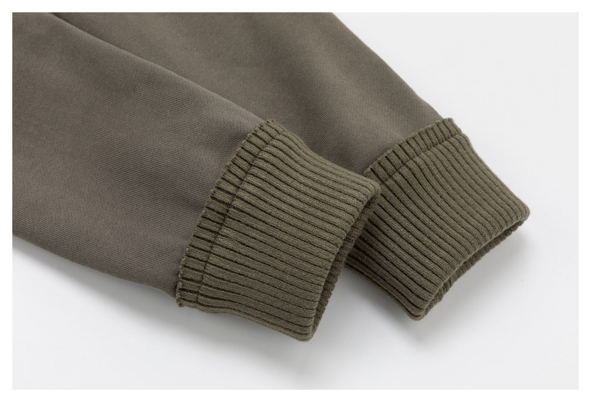 Close-up of a muted olive-brown garment sleeve with wide ribbed cuffs.