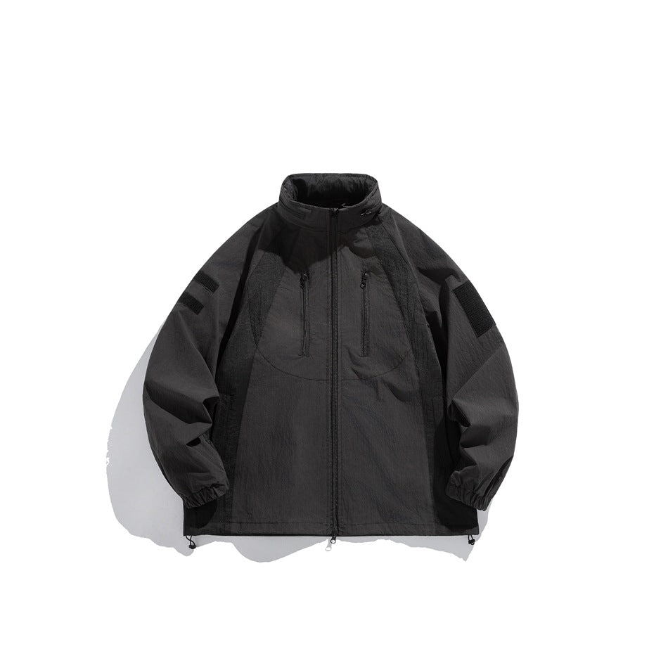 Black zip jacket with stand collar, chest zip pockets, sleeve patches and elastic cuffs, flat front view