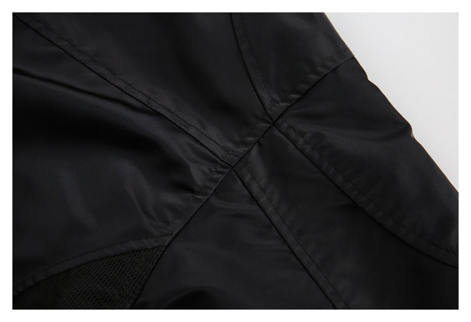 Close-up of a black jacket showing intersecting stitched seams and a small mesh section.