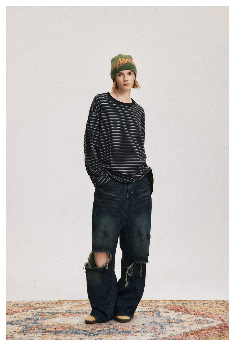 Full-length front view of a model wearing an oversized black long-sleeve shirt with fine gray stripes.
