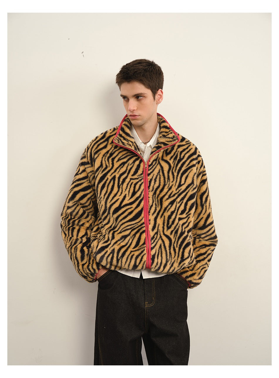 Man wearing a tiger-stripe plush zip jacket with red trim over a white shirt and dark jeans