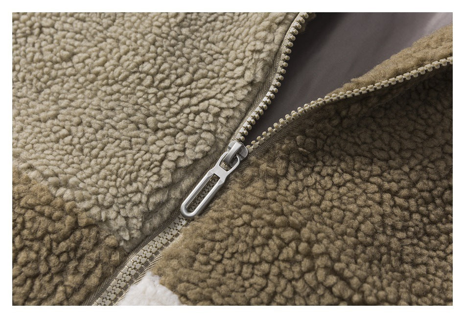 Close-up of a silver zipper pull on a taupe zipper set into looped fleece.
