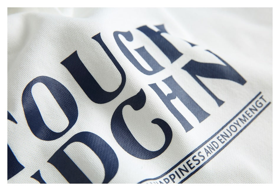 Angled close-up of navy lettering and a small slogan printed on white hoodie fabric.