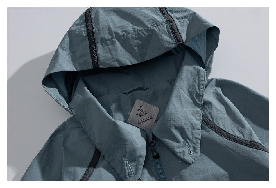 Close-up of a blue-gray jacket hood and collar, showing the lining, zipper, and sewn label.
