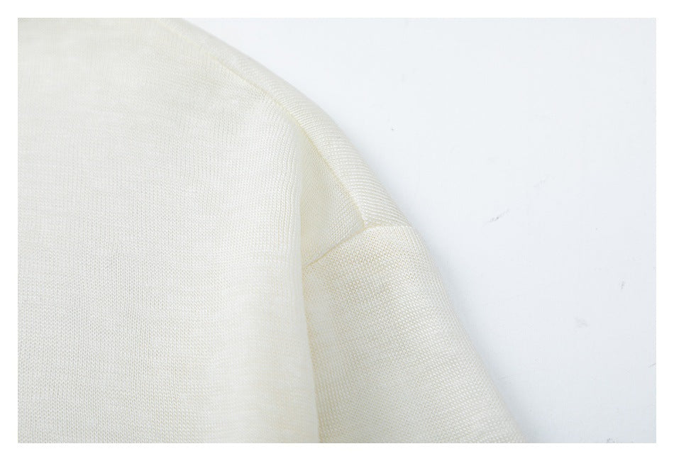 Close-up of an ivory garment seam and folded fabric edge.