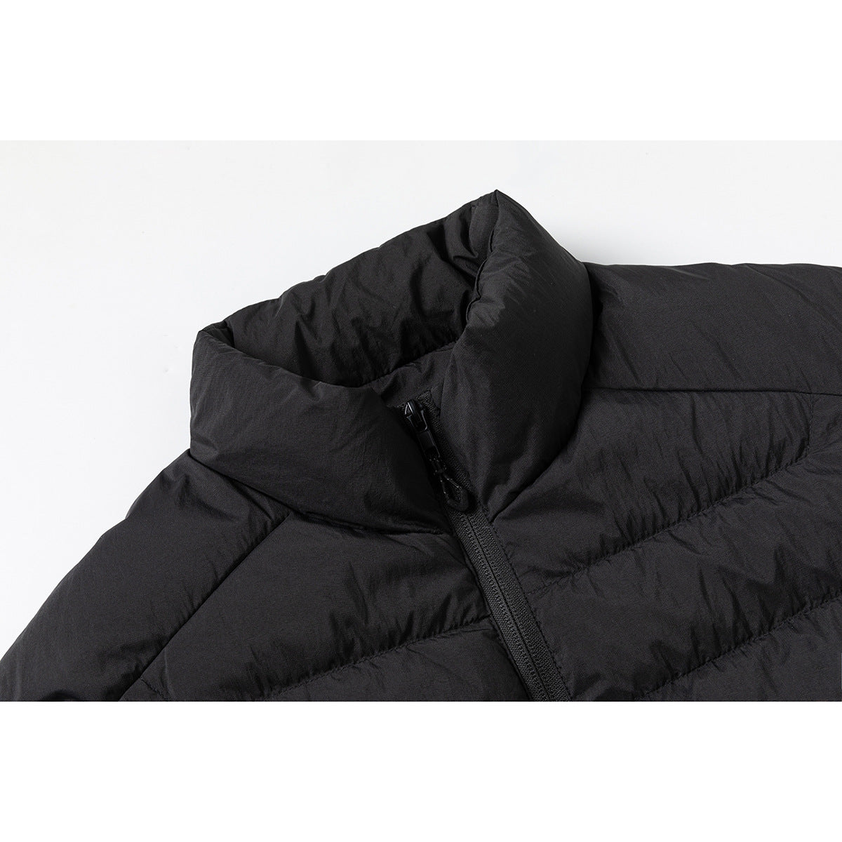 Close-up of a black quilted jacket's tall stand collar and front zipper.