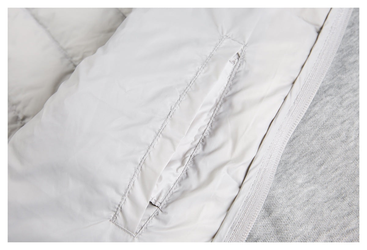 Close-up of a stitched pocket detail on the light gray jacket beside a heather-gray panel.