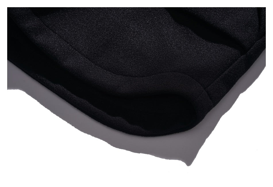 Close-up of the curved lower hem and edge stitching of a black coat.