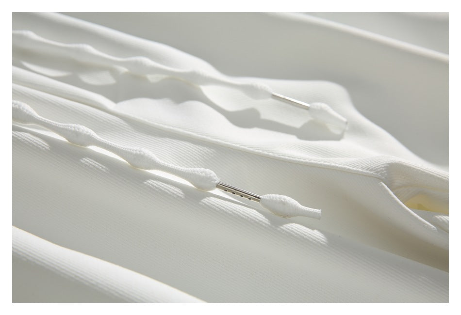 Close-up of the white drawstrings with metal tips against the pants fabric.