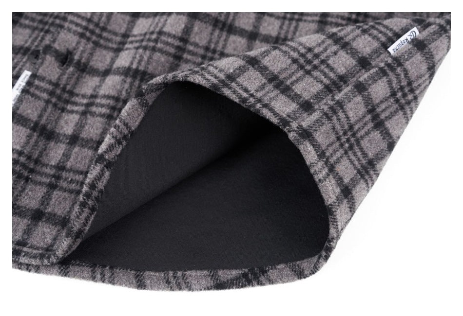 Gray and black plaid garment turned back to show its dark lining and sewn edge labels.