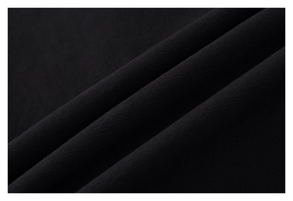 Macro view of black fabric arranged in soft diagonal folds.