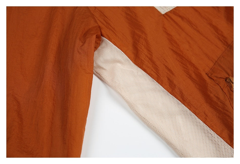 Close-up showing a pale mesh lining panel between rust-colored jacket fabric sections.